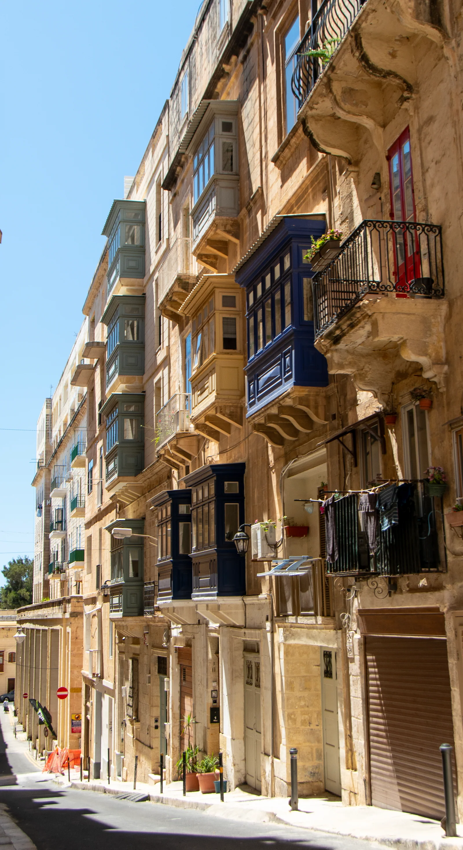Traditional enclosed balconies on a limestone street in Valletta, Malta
