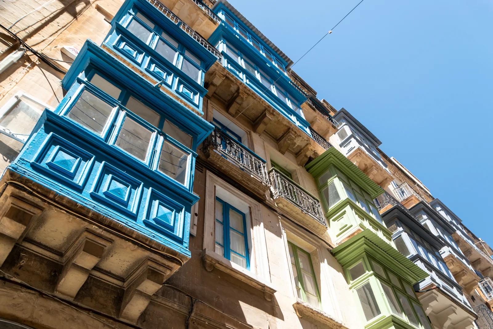 Traditional coloured balconies and limestone facades in Valletta, Malta
